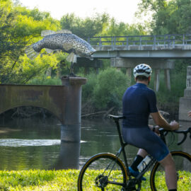 Two cyclists relaxing next to the Murray River at Tintaldra Bridge on the Border Loop